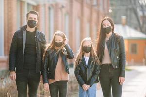 Family wearing a mask on a background of a modern building, photo