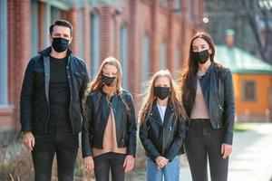 Family wearing a mask on a background of a modern building, photo