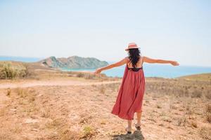 Tourist woman outdoor on edge of cliff seashore photo