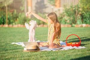 Little smiling girl playing with puppy in the park photo