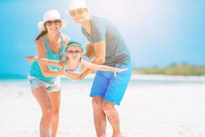 Young family on white beach during summer vacation photo