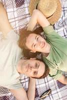 Picnic time. Young couple having fun on picnic in the park. photo