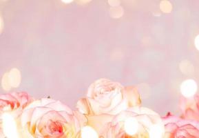 Frame of gentle pale pink roses and bokeh lights on pink. Festive abstract floral mock up. photo