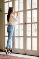 Beautiful girl on the terrace looks in a large window in a cozy boutique hotel photo