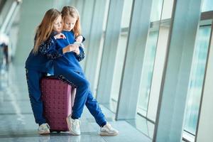 Little adorable girls in airport near big window photo