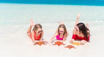 familia de mamá e hijos en la playa tropical foto