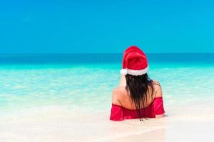 Young woman enjoying the sun sunbathing by perfect turquoise ocean. photo