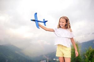 Beautiful happy little girl in mountains in the background of fog photo