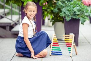 Happy little schoolgirl with a chalkboard outdoor photo