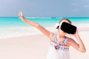 Kid wearing virtual reality glasses on beach photo