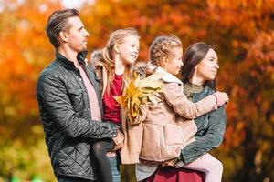 Portrait of happy family of four in autumn day photo