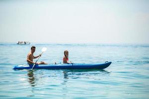 familia deportiva atractiva en kayak en el mar juntos foto