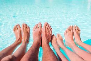 Close up of four people's legs by pool side photo