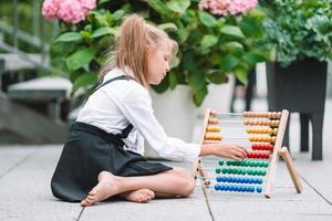 Happy little schoolgirl with a chalkboard outdoor photo