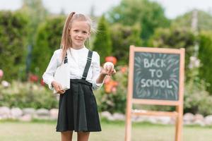 Happy little schoolgirl with a chalkboard outdoor photo