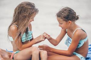 Little girls having fun at tropical beach playing together photo