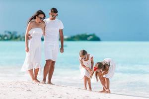 Happy beautiful family with kids on the beach photo