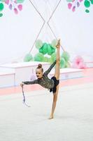 pequeña gimnasta entrenando en la alfombra y lista para las competencias foto