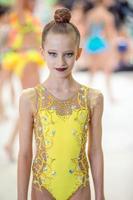 Beautiful little active gymnast girl with her performance on the carpet photo