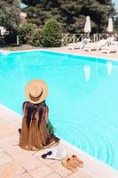 Woman relaxing by the pool in a luxury hotel resort enjoying perfect beach holiday vacation photo