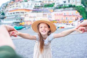 Adorable little girl on warm and sunny summer day in Positano town in Italy photo