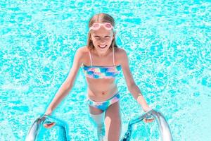 Little adorable girl in outdoor swimming pool photo