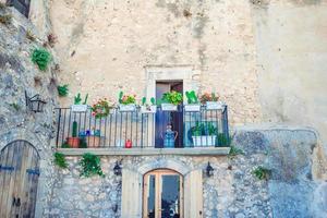 The narrow streets of the island with blue balconies, stairs and flowers. photo