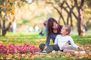 niña con mamá al aire libre en el parque en el día de otoño foto