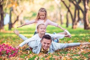 Family of dad and kids on beautiful autumn day in the park photo