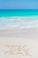 Happy New Year written in the white sand photo