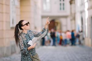 mujer joven con un mapa de la ciudad en la ciudad. chica turística de viaje con mapa en viena al aire libre durante las vacaciones en europa. foto