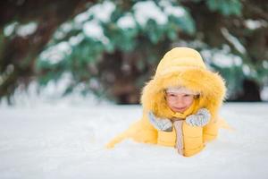 Portrait of little adorable girl with beautiful green eyes in snow sunny winter day photo
