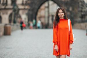 Happy young urban woman in european city on the famous bridge. Warm summer early morning in Prague, Czech Republic photo