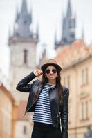 mujer joven feliz con sombrero en la calle de la ciudad europea. foto