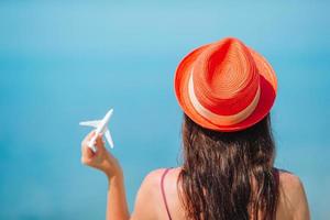 Miniature toy airplane in female hands. Trip by airplane. Conceptual image for travel and tourism. photo