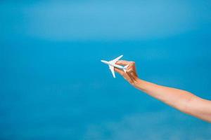 Miniature toy airplane in female hands. Trip by airplane. Conceptual image for travel and tourism. photo