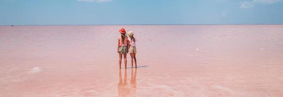 Girls on a pink salt lake on a sunny summer day. photo