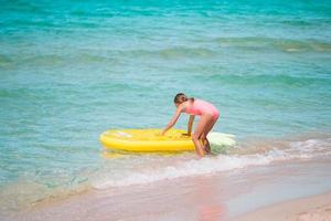 Adorable girl on inflatable air mattress in the sea photo