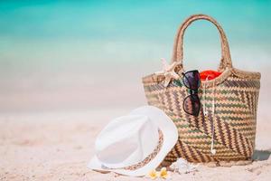 Beach accessories - straw bag, hat and unglasses on the beach photo