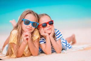 Two little happy girls have a lot of fun at tropical beach playing together photo