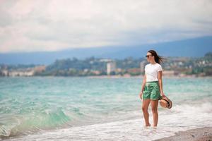 Young happy woman on the beach with mountain view photo