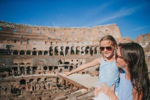 Young mother and little girl hugging in Coliseum, Rome, Italy. photo