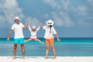 Happy family of three having fun together on the beach photo