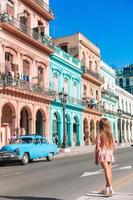 chica turista en zona popular en la habana, cuba. niño joven viajero sonriendo foto