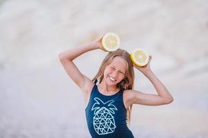 Adorable little girl have fun at tropical beach during vacation photo