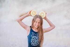 Adorable little girl have fun at tropical beach during vacation photo