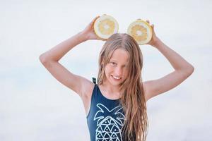 Adorable little girl have fun at tropical beach during vacation photo