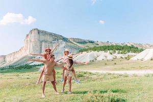 Happy family of four walking in the mountains photo