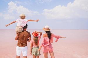 Family walk on a pink salt lake on a sunny summer day. photo