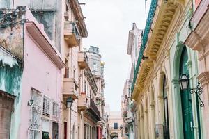 vista auténtica de una calle de la habana vieja con edificios y autos antiguos foto